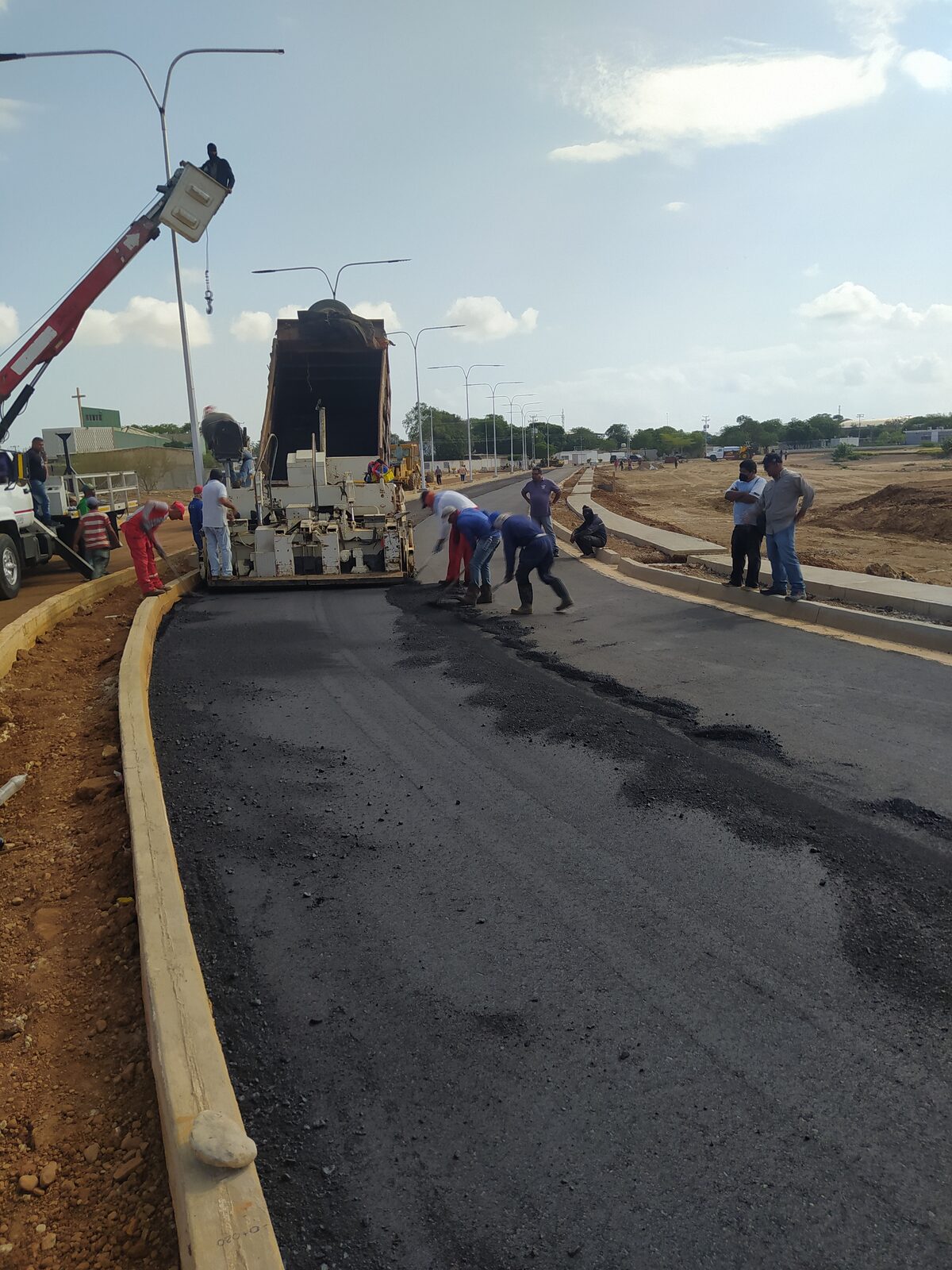 Cuadrilla de Consfigca colocando carpeta asfáltica con pavimentadora en el distribuidor vial de la zona sur de Coro