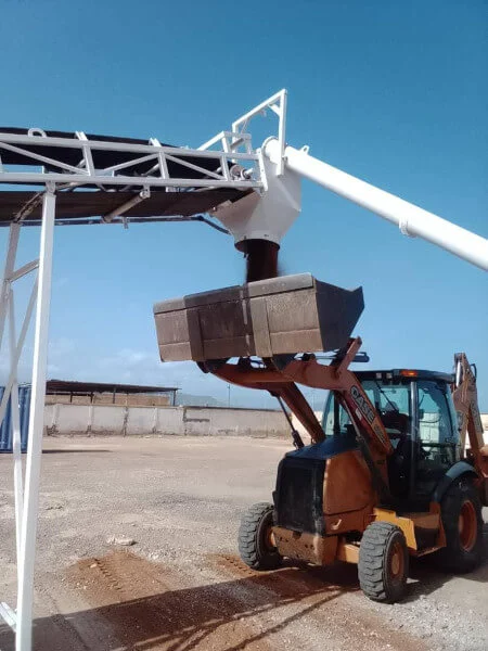 Montacargas cargando material en la tolva de la planta de concreto premezclado