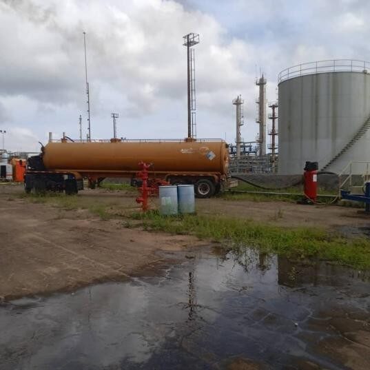 Patio de tanques de almacenamiento con camión cisterna en operación