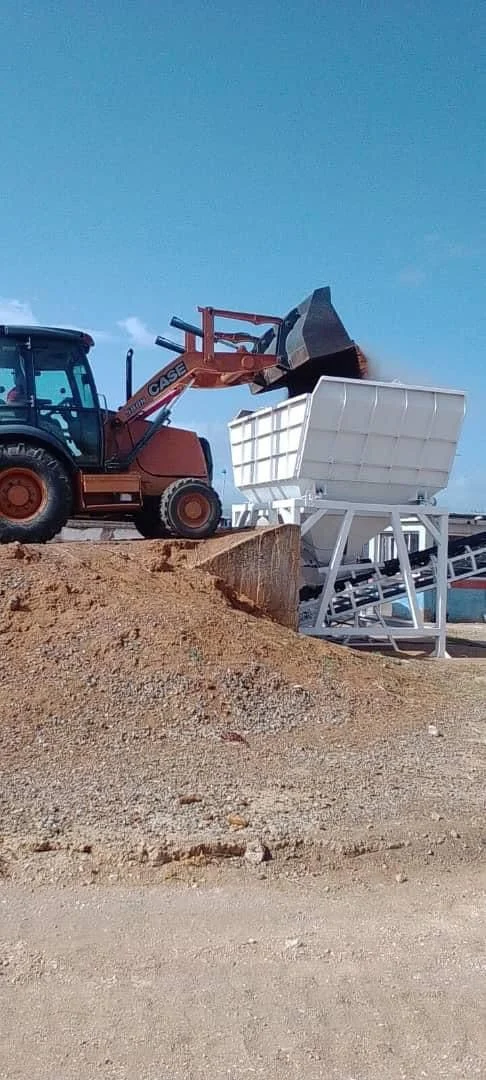 Cargador frontal descargando material en la tolva dosificadora de la planta